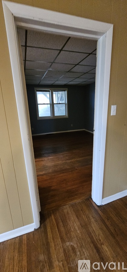 A room with a window and wooden flooring.