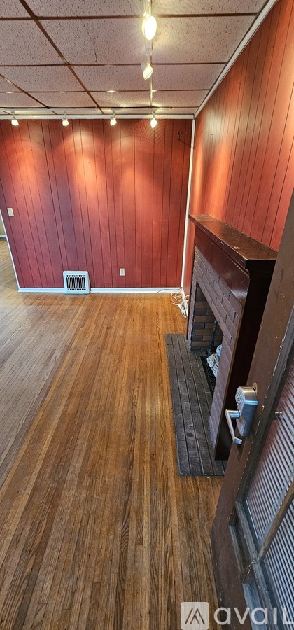 A room with wooden floors and a red wall.