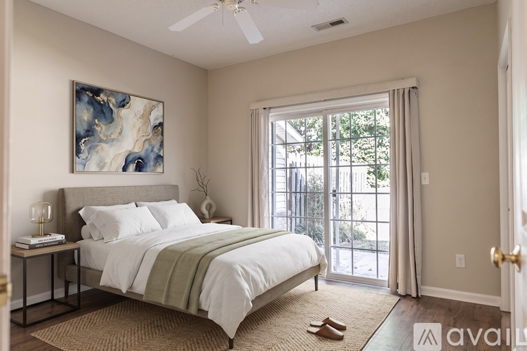 A bedroom with a large bed and a painting on the wall.