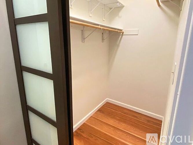 A hallway with a wooden floor and white walls.