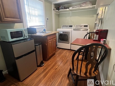 A kitchen with a microwave, oven, and refrigerator.