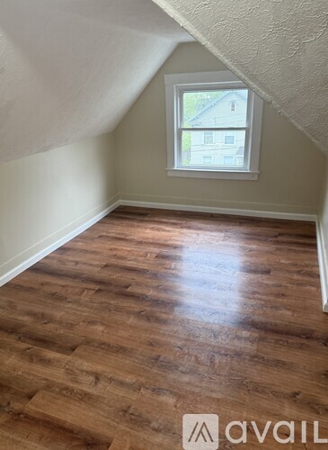 A room with wooden flooring and a window.