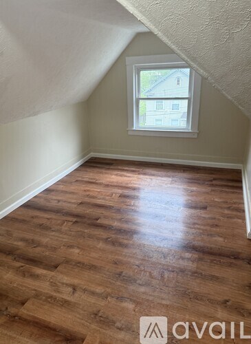A room with wooden flooring and a window.