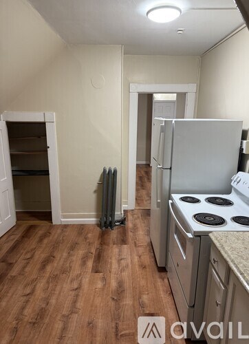A kitchen with a stove, refrigerator, and a small pantry.
