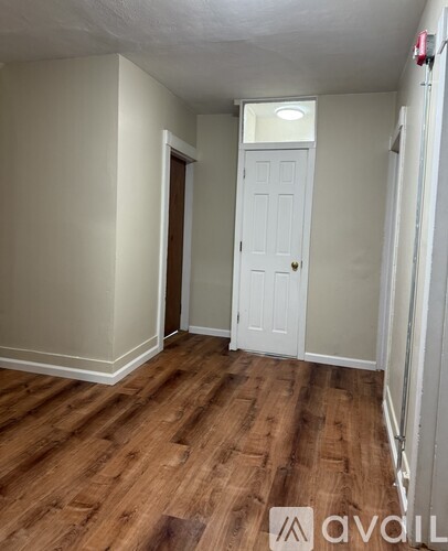 A room with wooden floors and two doors.