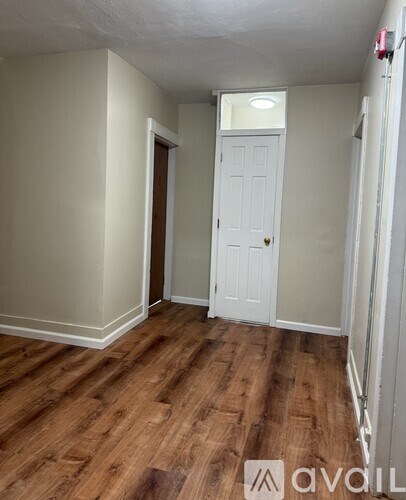 A room with wooden floors and two doors.