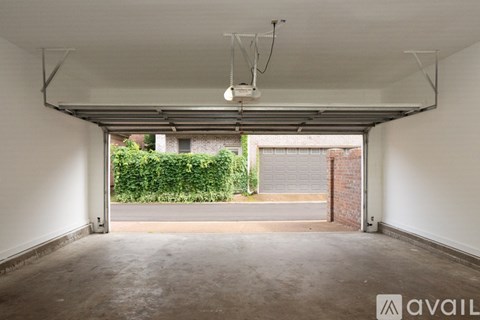 A spacious garage with a view of a residential area through the open door.