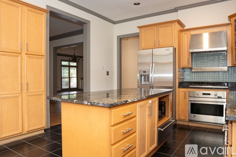 A kitchen with wooden cabinets and a marble countertop.