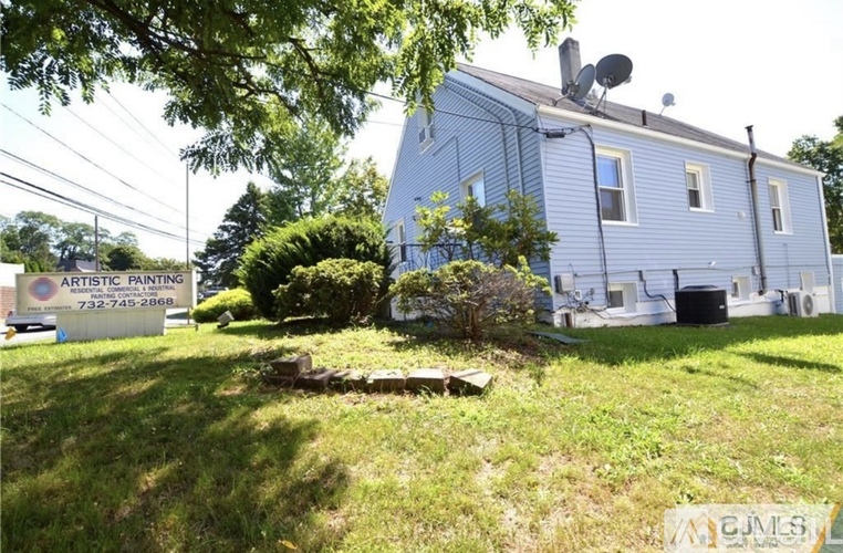A blue house with a sign that says Artistic Painting.