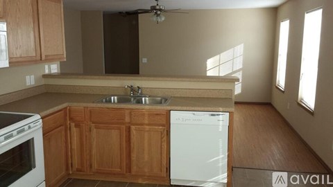 A kitchen with wooden cabinets and a white dishwasher.