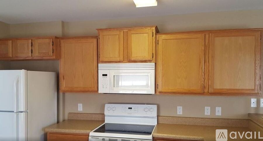 A kitchen with wooden cabinets and a white fridge.