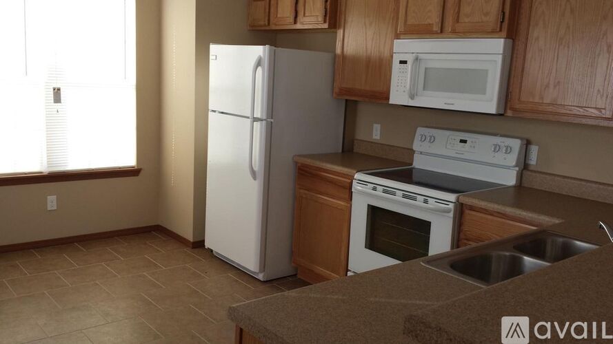 A kitchen with a white refrigerator, white microwave, white oven, and white dishwasher.