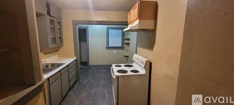 A small kitchen with a stove top oven and a sink.