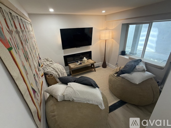 A bedroom with two beds and a television mounted on the wall.