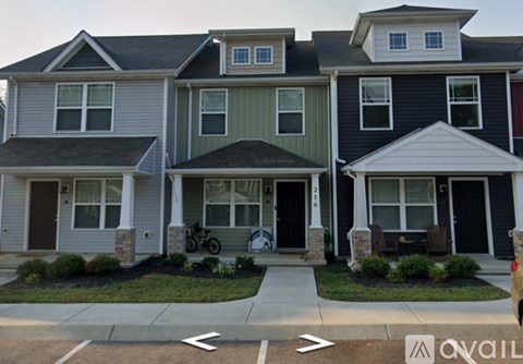 A row of houses with a car parked in front of the first one.