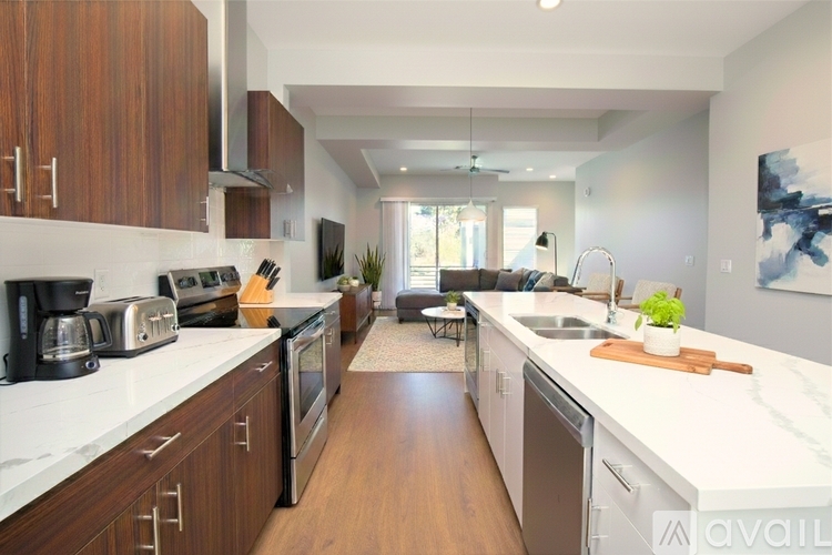 A modern kitchen with dark wood cabinets and white countertops.