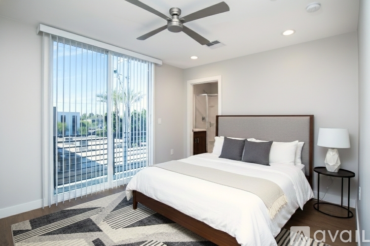 A bedroom with a large bed and a ceiling fan.