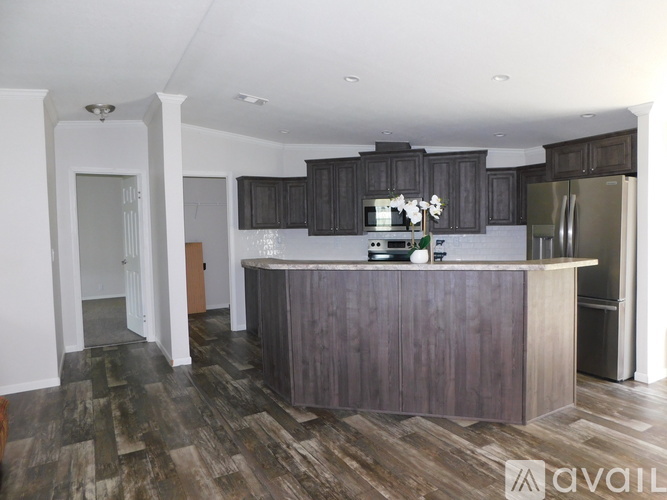 A kitchen with a wooden island and dark brown cabinets.