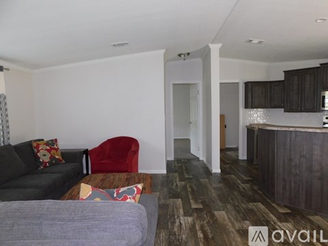 A living room with a grey couch and a red chair.