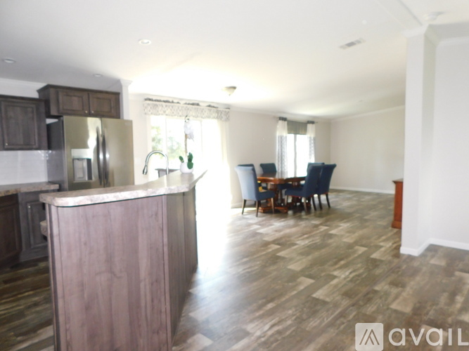 A kitchen with a wooden island and a dining table with chairs.
