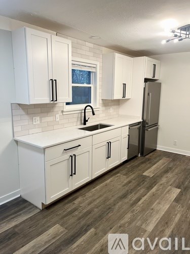 A kitchen with white cabinets and a refrigerator.