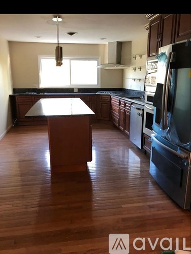 A kitchen with wooden floors and a central island.