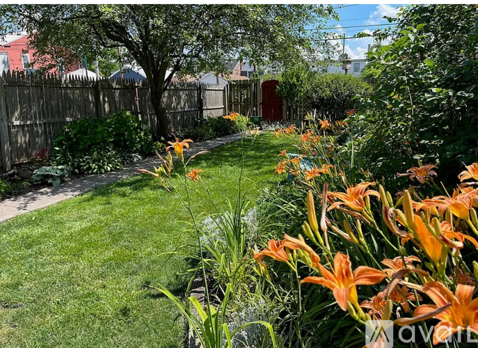 A garden with green grass and orange flowers.