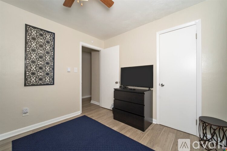 A room with a ceiling fan and a wall hanging picture.