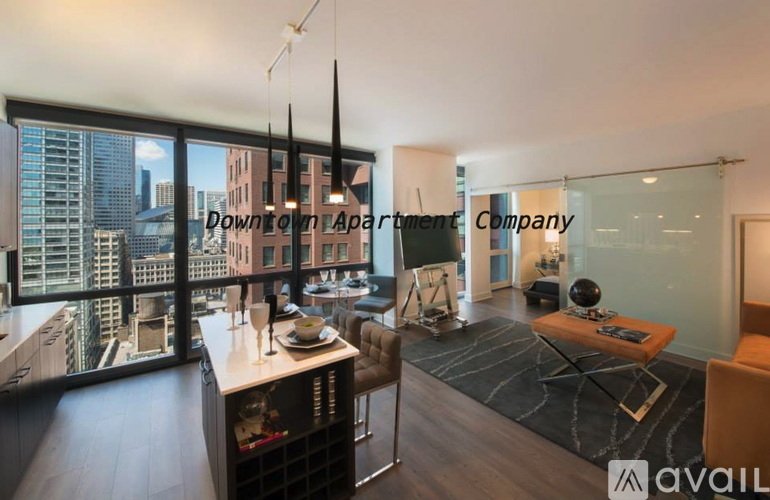 A living room with a view of the cityscape outside the window.