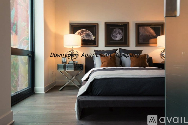 A bedroom with a bed, nightstand, and two wall art pieces.