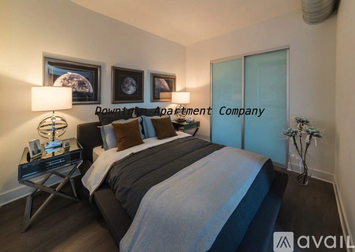 A bedroom with a bed, nightstand, and two wall art pieces.