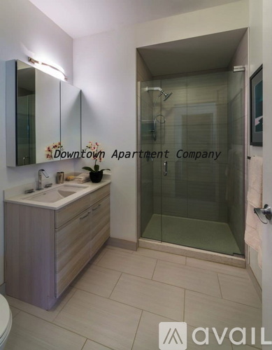 A bathroom with a sink, mirror, and glass shower door.