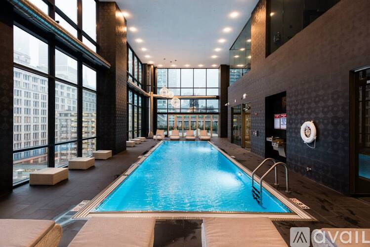 A large indoor swimming pool with a view of the city outside the windows.