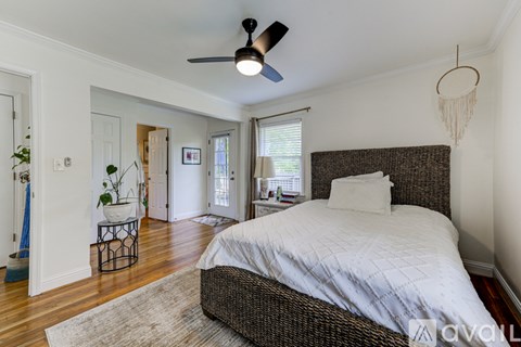 A bedroom with a large bed and a ceiling fan.