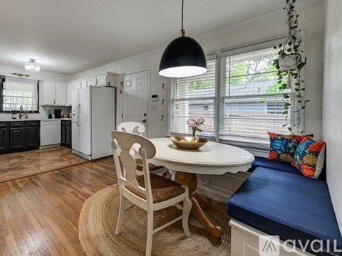 A dining area with a white table and chairs.