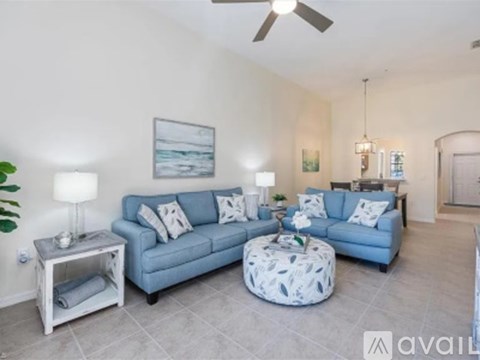 A living room with a blue couch and a white coffee table.