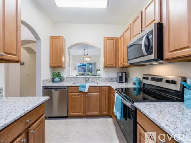 A kitchen with wooden cabinets and granite countertops.