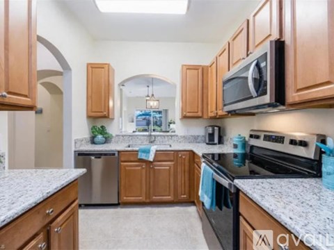 A kitchen with wooden cabinets and granite countertops.