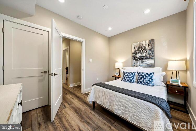 A bedroom with a large bed and a painting on the wall.