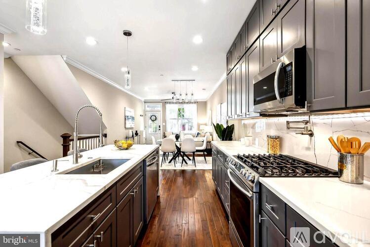 A modern kitchen with dark wood cabinets and white countertops.