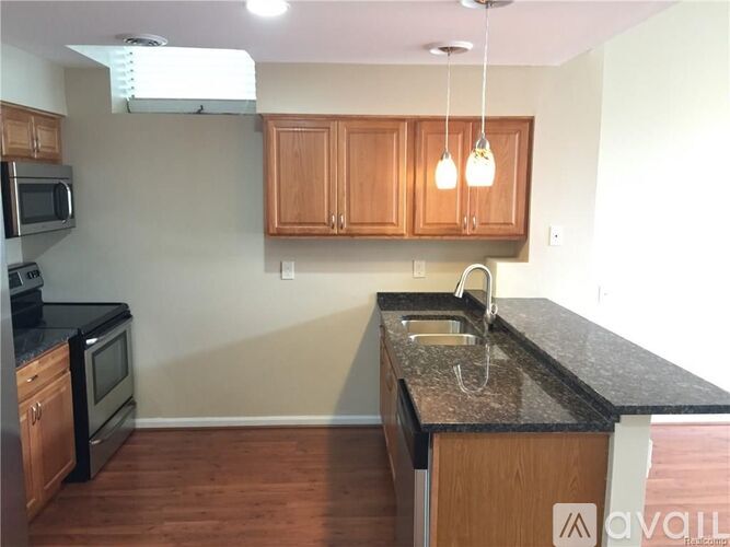 A kitchen with wooden cabinets and black countertops.