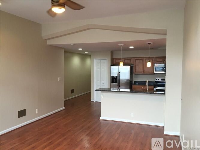 A kitchen with a refrigerator, oven, and cabinets.