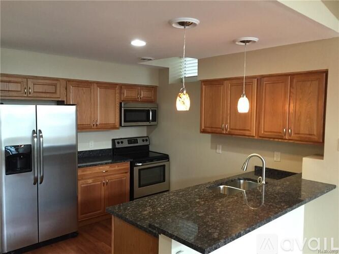 A kitchen with wooden cabinets and granite countertops.