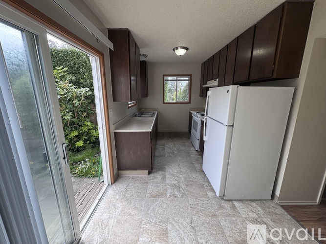 A kitchen with a white refrigerator and wooden cabinets.