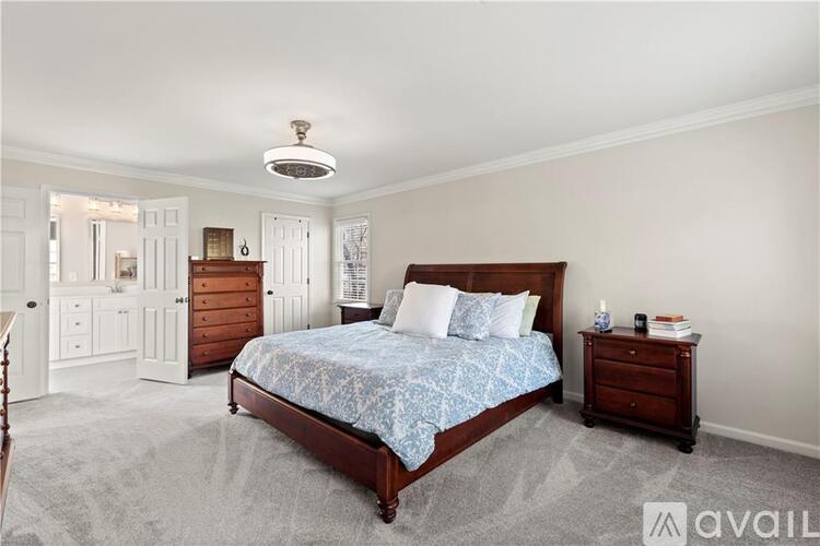 A bedroom with a bed, nightstand, and dresser.