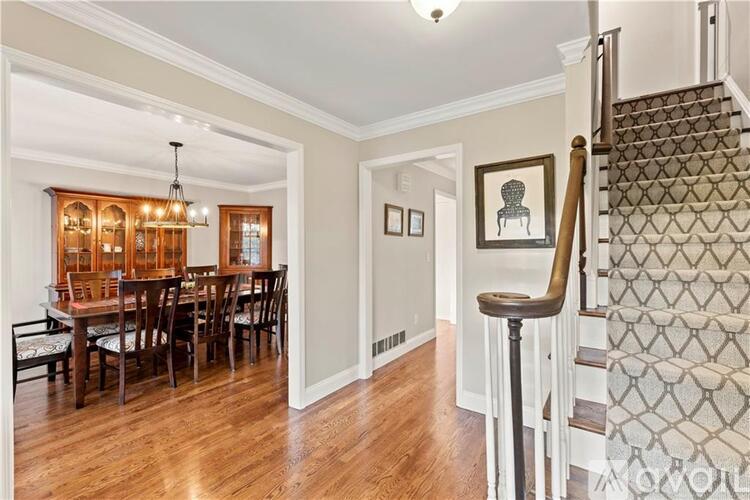 A dining room with a wooden table and chairs.
