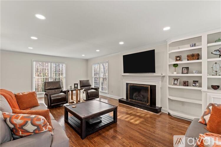 A living room with a fireplace and a television mounted on the wall.
