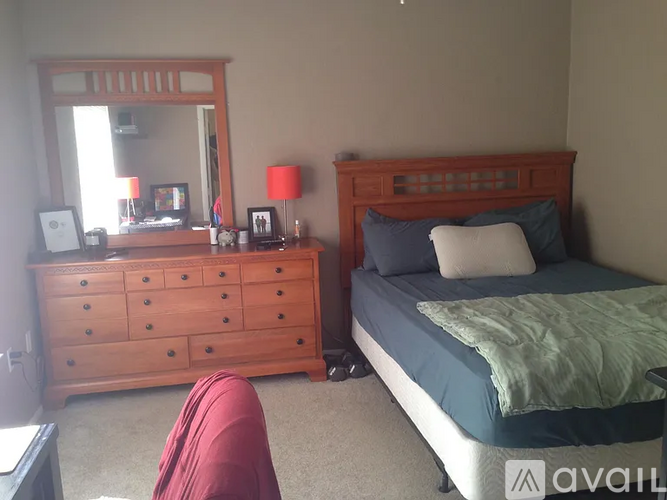 A bedroom with a bed, dresser, and mirror.