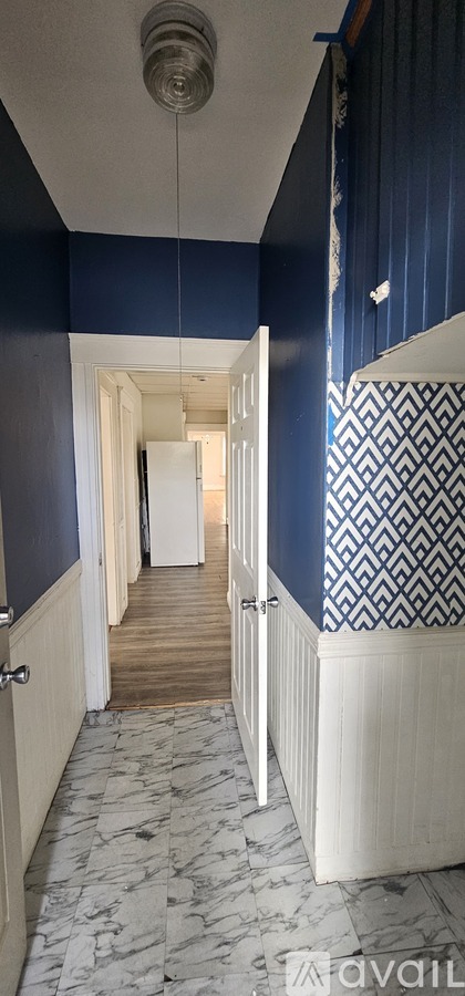 A hallway with a white door and a white cabinet.