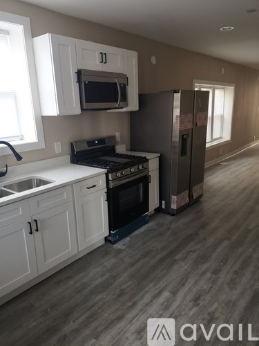 A kitchen with white cabinets and a black stove top oven.